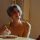 A senior woman is writing in her journal at home, enjoying a peaceful and reflective moment